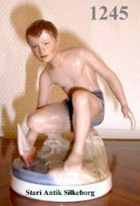 Dreng med skib. H. 14,5 cm.  kr 3500.-